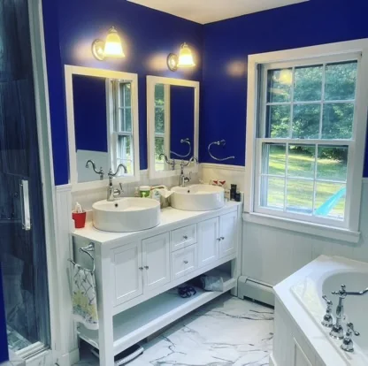 Blue bathroom with white vanity and wall lighting