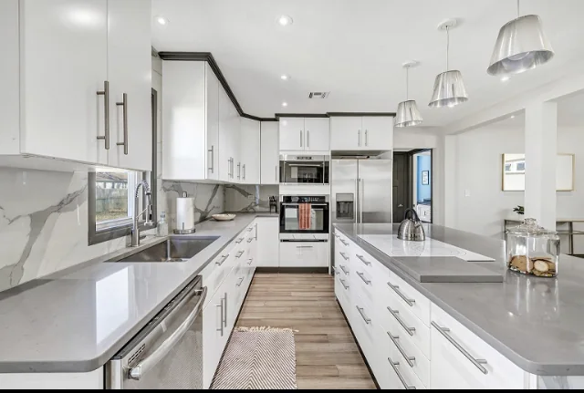 White kitchen with long island and pendant lighting